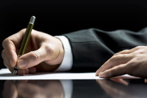 Estate Planning Lawyer Barrington, IL - man hand in dress suit signing paper with pen